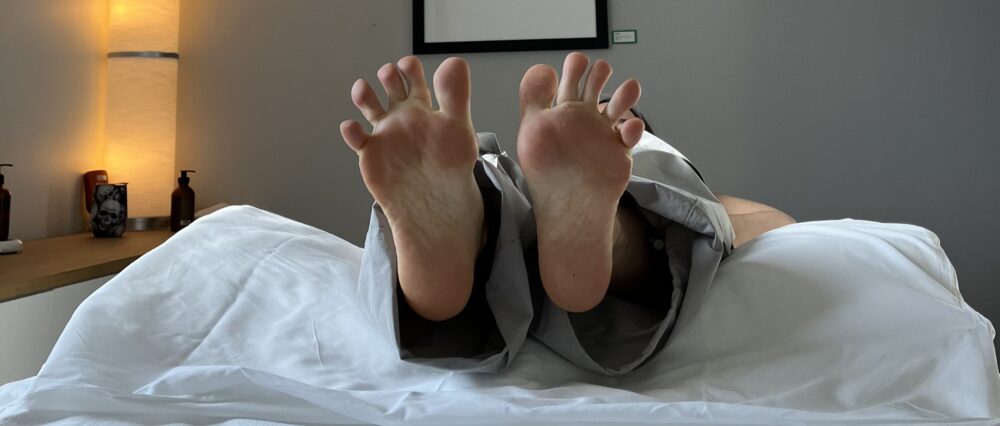 Client lying on the massage table spreading their toes